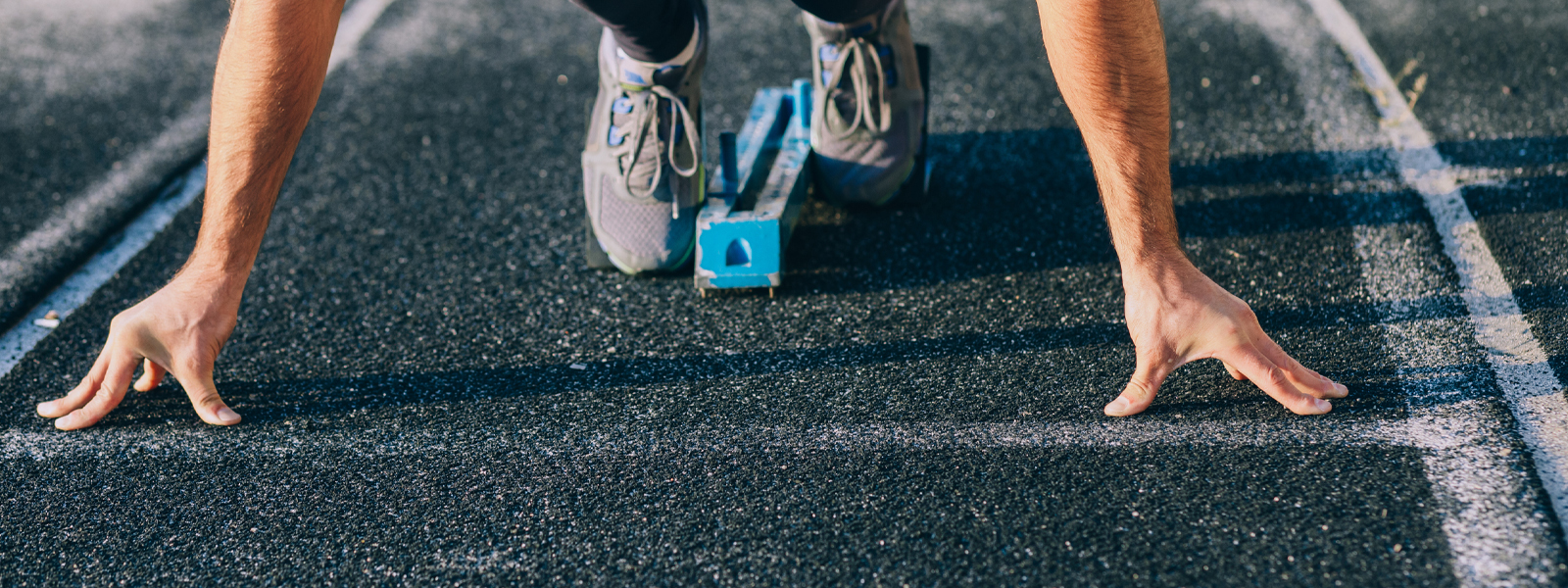 Person getting ready to run on a track. 