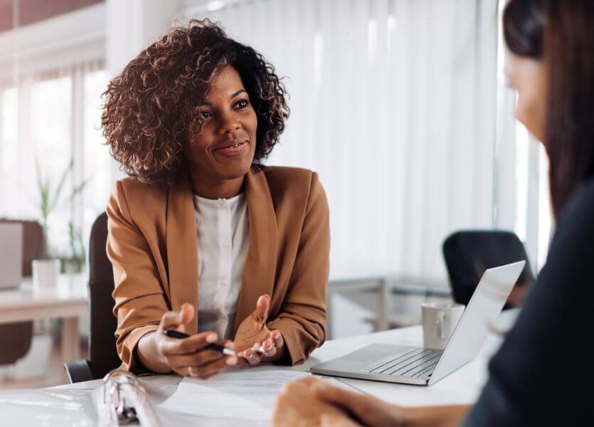 A young, professional woman assists a client 