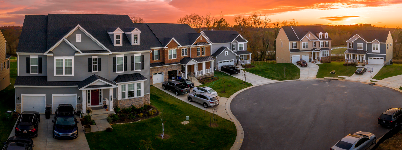 A house in a suburban neighborhood while the sun sets. 