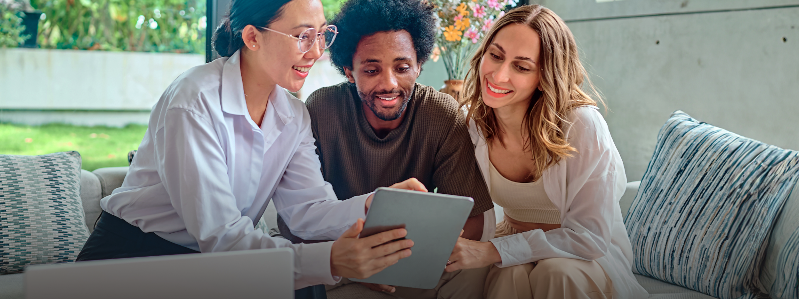 Three people smiling, looking at a phone screen. 