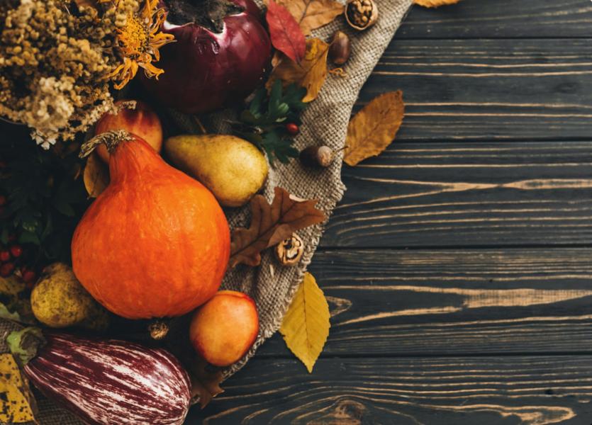 A collection of Thanksgiving gourds on a wooden table. 