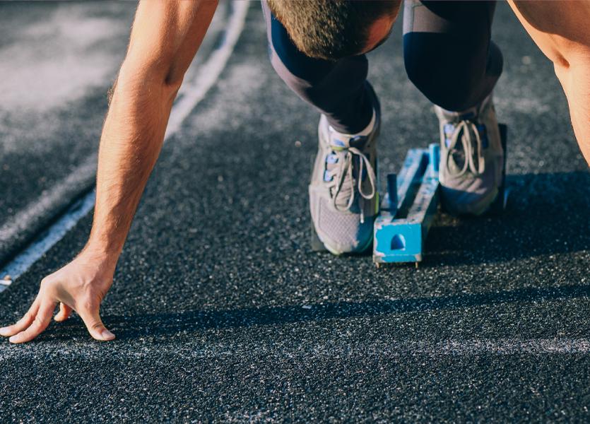 Person getting ready to run on a track. 