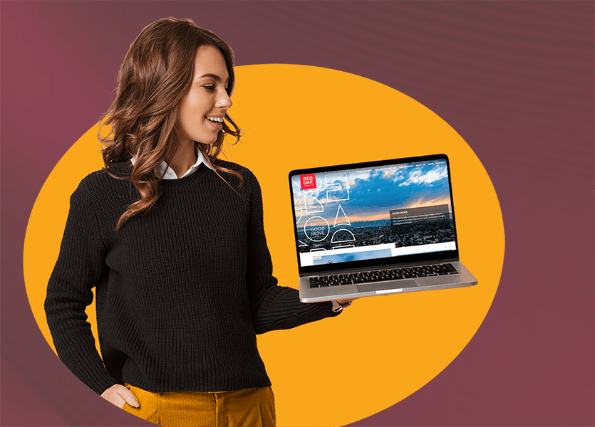 A smiling woman holding a laptop. 